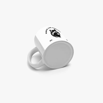 White coffee mug with black interior featuring rebellious coon face design and "Kunts Live Forever" text in punk style